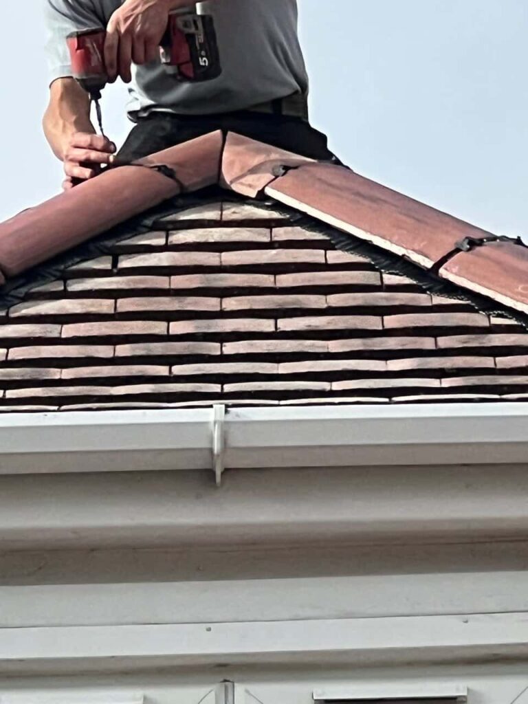 This is a photo of one of the operatives of Bilsthorpe Roofing Repairs installing new ridge tiles