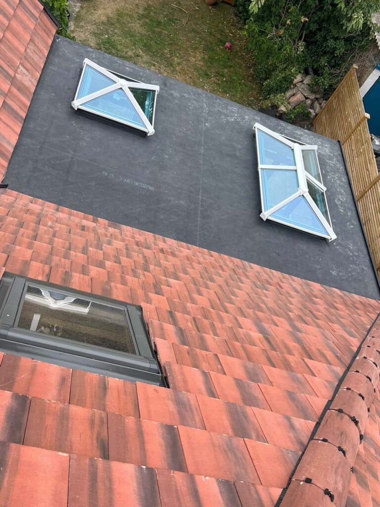 This is a photo taken from the roof ridge looking down a tiled pitched roof on to a flat roof. Works carried out by Bilsthorpe Roofing Repairs